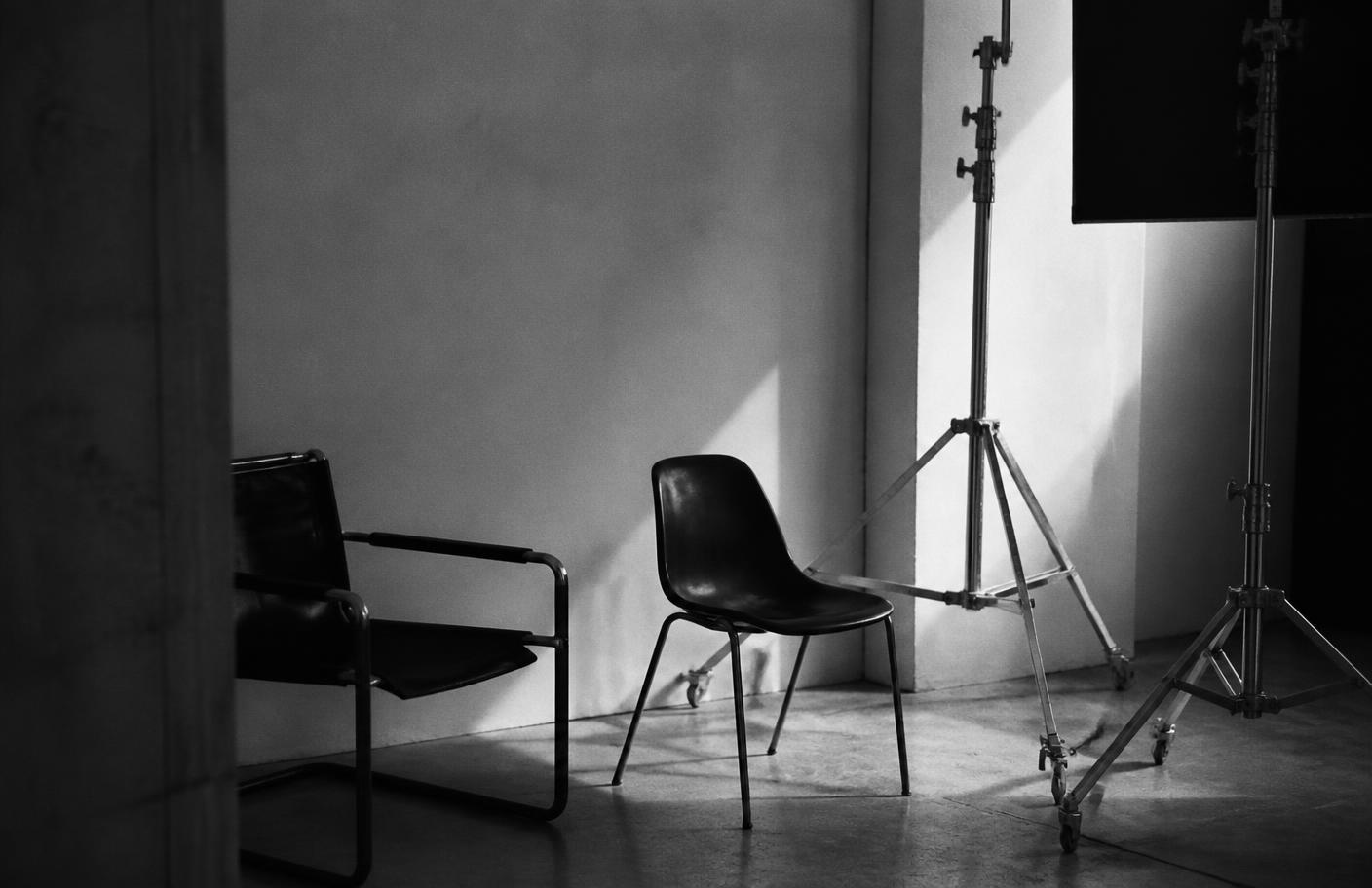 Empty studio chairs and lighting stands in a quiet production space